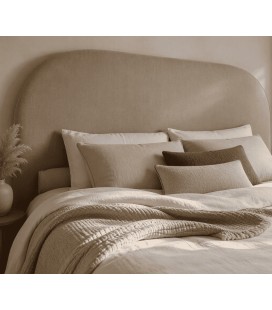 Tête de lit arrondie en coton biologique dans une chambre scandinave beige et bois clair